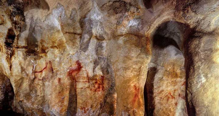 La Pasiega, section C, cave wall with paintings. The ladder shape composed of red horizontal and vertical lines (centre left) dates to older than 64,000 years and was made by Neanderthals. © P. Saura